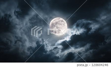 A stunning view of a full moon shining through thick, dark night clouds. 128604246