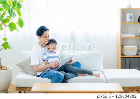 リビングでタブレットを見る家族 128604802