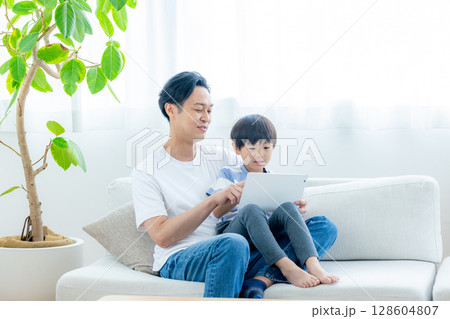 リビングでタブレットを見る家族 リビングでタブレットを見る家族 128604807