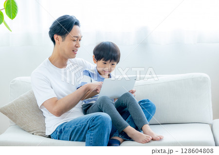 リビングでタブレットを見る家族 128604808