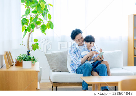 スマホを見るパパと子供 128604848