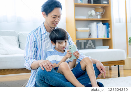 スマホを見るパパと子供 128604850