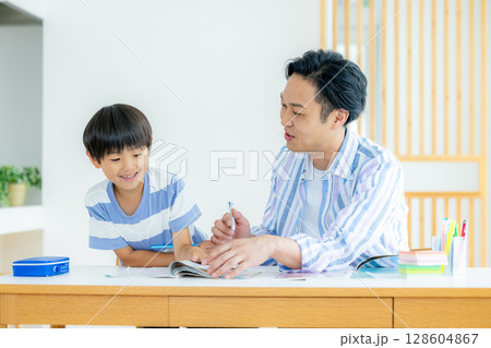 リビングで勉強をする子供と父親 128604867