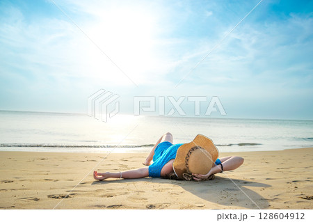 Rear View of young model lying with hat on beach at Patong beach Rear View of young model lying with hat on beach at Patong beach 128604912