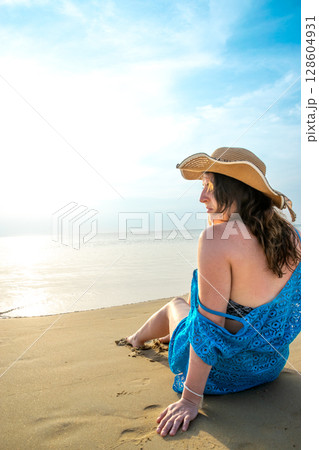 Rear view of young model observing horizon with hat on beach at Patong beach Rear view of young model observing horizon with hat on beach at Patong beach 128604931