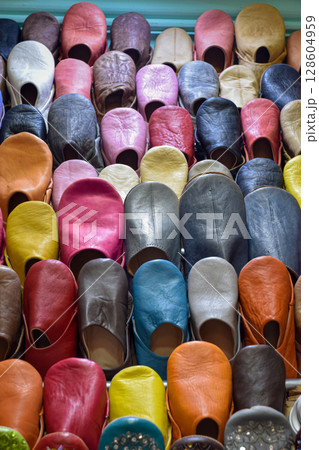 Close up view of Slippers or sandals of many colors hung from street stalls Close up view of Slippers or sandals of many colors hung from street stalls 128604959