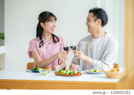 赤ワインで乾杯する若い男女 赤ワインで乾杯する若い男女 128605281