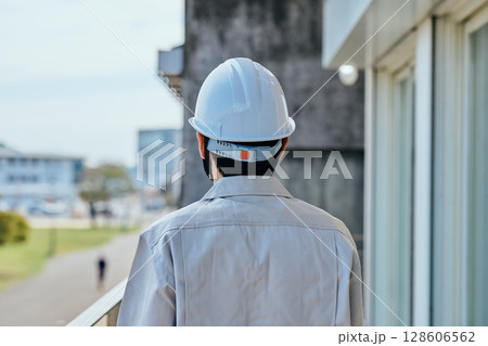 ヘルメットをかぶった作業服姿の若い男性 128606562