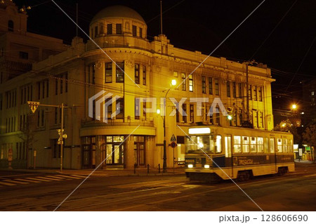 【運転手ロゴぼかし済】函館地域交流まちづくりセンターの前を行く路面電車 128606690