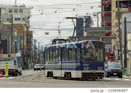【ナンバーロゴ人物ぼかし済】函館市松風町の交差点通過の路面電車 128606967