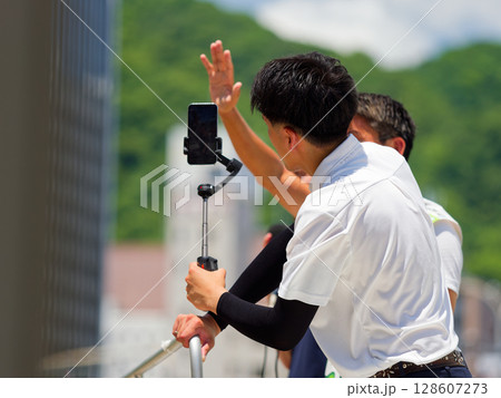 選挙の街頭演説をスマホで動画発信する人 選挙の街頭演説をスマホで動画発信する人 128607273