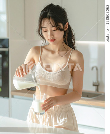 ミルクを注ぐ若い女性 128608062