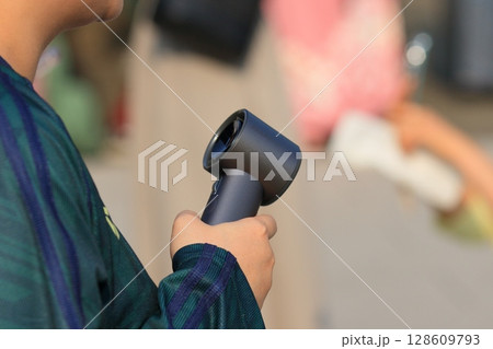 ハンディファンを持って歩く女性 ハンディファンを持って歩く女性 128609793