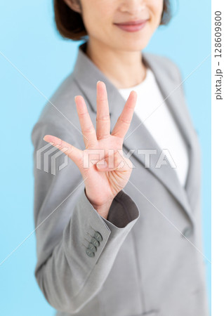 グレーのスーツを着て4本指を立てるミドル女性ビジネスウーマン グレーのスーツを着て4本指を立てるミドル女性ビジネスウーマン 128609800