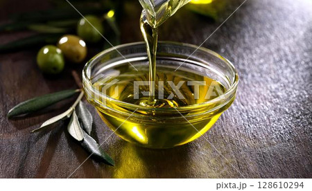 ガラスの小さな器にオリーブオイルを注いでいる 128610294