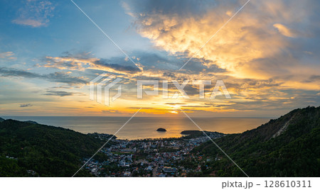 Vibrant Sunset Over Coastal Town and Hills 128610311