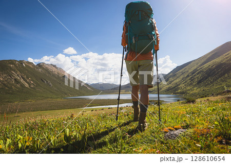 Backpacking female hiker wearing leather boots hiking on high altitude grassland mountains Backpacking female hiker wearing leather boots hiking on high altitude grassland mountains 128610654