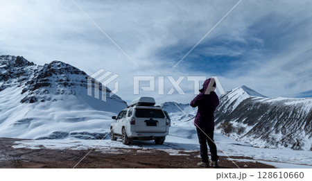 Woman photographer remote control a drone on high altitude mountain top, China Woman photographer remote control a drone on high altitude mountain top, China 128610660