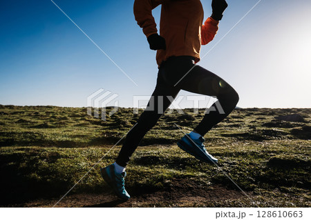 Woman trail runner cross country running to high altitude mountain peak Woman trail runner cross country running to high altitude mountain peak 128610663