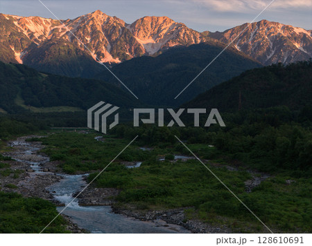美しい白馬三山の夏のモルゲンロートと松川 長野県白馬村(ドローンによる空撮) 美しい白馬三山の夏のモルゲンロートと松川 長野県白馬村(ドローンによる空撮) 128610691