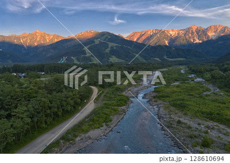 美しい白馬連峰の夏のモルゲンロートと松川　長野県白馬村（ドローンによる空撮） 128610694