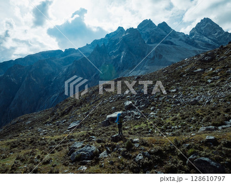 Backpacking woman climbing up on steep cliff edge at high altitude mountains top Backpacking woman climbing up on steep cliff edge at high altitude mountains top 128610797