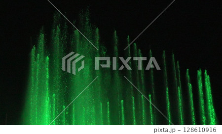 Fountains Green Water Night Show: Illuminated water jets display vibrant green light at nighttime. Fountains Green Water Night Show: Illuminated water jets display vibrant green light at nighttime. 128610916
