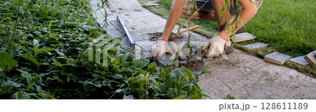 Laying paving stones on cement mortar. Laying a garden path made of tiles. Self-laying of concrete paving slabs in the courtyard of the house. do it yourself. DIY Laying paving stones on cement mortar. Laying a garden path made of tiles. Self-laying of concrete paving slabs in the courtyard of the house. do it yourself. DIY 128611189