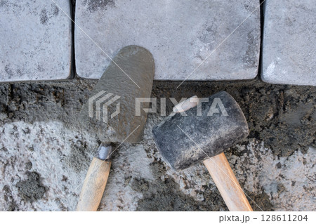 Laying paving stones on cement mortar. Laying a garden path made of tiles. Self-laying of concrete paving slabs in the courtyard of the house. do it yourself. DIY 128611204