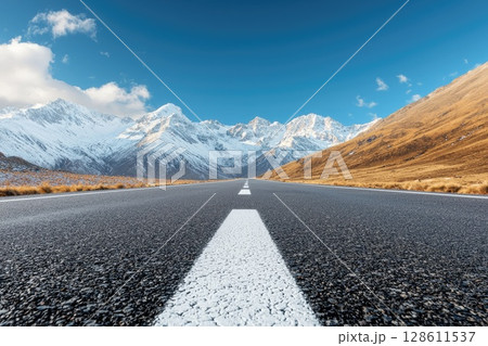 Ground Level Road View with Mountains in Background 128611537