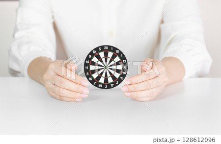 Hands Holding Dartboard Illustrating Focus, Accuracy and Protected Goal Achievement Hands Holding Dartboard Illustrating Focus, Accuracy and Protected Goal Achievement 128612096