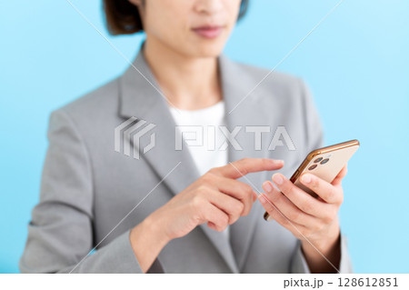 スマホを操作するミドル女性ビジネスウーマン 128612851