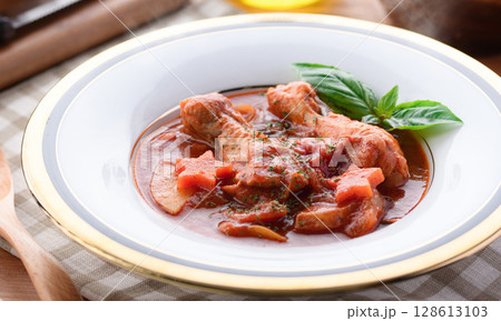 鶏手羽元のトマト煮込みとパンの洋食テーブルイメージ 鶏手羽元のトマト煮込みとパンの洋食テーブルイメージ 128613103