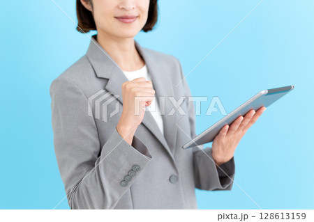タブレットを持ってガッツポーズをするミドル女性ビジネスウーマン タブレットを持ってガッツポーズをするミドル女性ビジネスウーマン 128613159