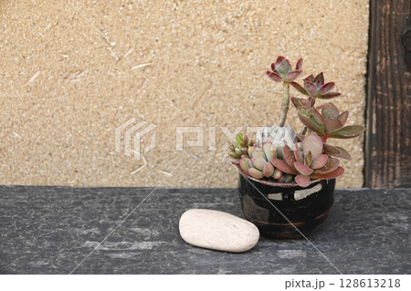 石見銀山 町並み地区 古民家の縁側に置かれている和陶器の多肉植物と白い石 128613218