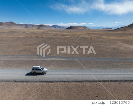 Aerial view of offroad car running on high elevation lakeside Aerial view of offroad car running on high elevation lakeside 128613760