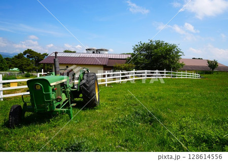 牧場の古い壊れたトラクターと白いフェンス 128614556