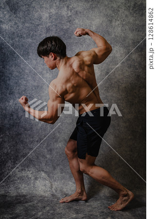 アーノルドポーズをとって筋肉美を誇る男性 128614862