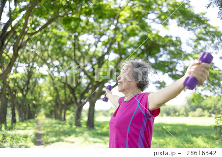 Happy Asian senior woman lifting dumbbell 128616342
