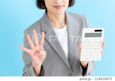 白い電卓を持って4本指を立てるミドル女性ビジネスウーマン 128616675