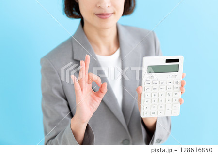 白い電卓を持って丸サインをするミドル女性ビジネスウーマン 128616850