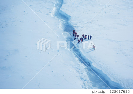 割れた南極の氷を観察する研究者たち 128617636