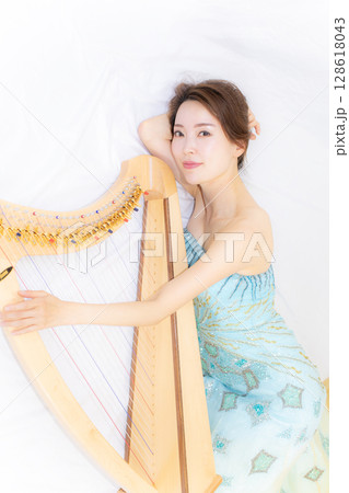 小型ハーブと音楽好きな若い女性 小型ハーブと音楽好きな若い女性 128618043