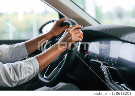 Close up view. Woman is sitting in a car and driving it 128618201