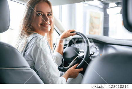Modern quality interior. Woman is sitting in a car and driving it 128618212