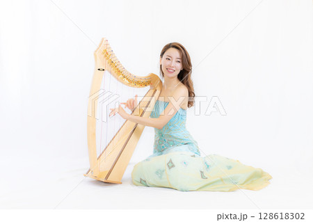 小型ハーブと音楽好きな若い女性 小型ハーブと音楽好きな若い女性 128618302