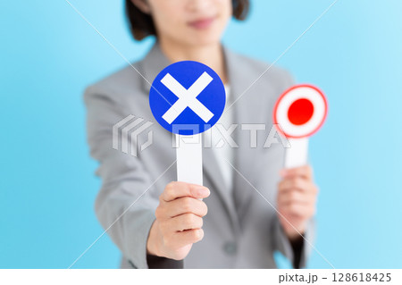 丸ばつのバツの札を持つミドル女性ビジネスウーマン 128618425