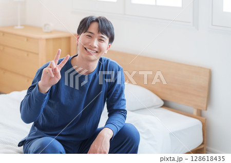 ベッドでピースする男性 ベッドでピースする男性 128618435