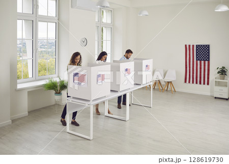 People voting standing in a row in voting booth at polling station at vote center. 128619730
