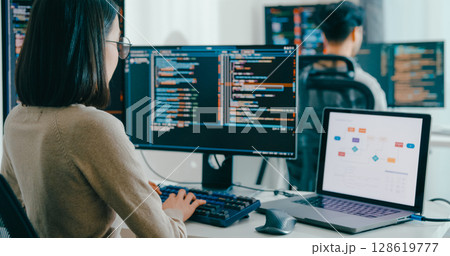 Closeup Adult Asia male, female freelance typing write prompt AI bot IT app smart program nomad, video game, terminal with coding language, user interface, designer, big data center desktop computer. 128619777